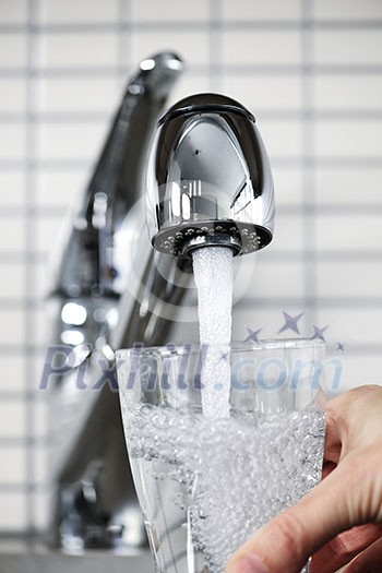 Filling glass of water from stainless steel kitchen faucet