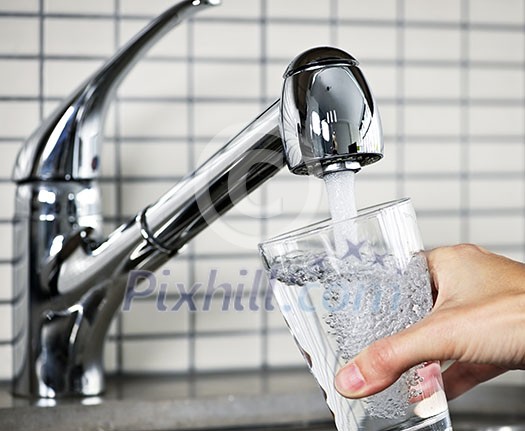 Filling glass of water from stainless steel kitchen faucet