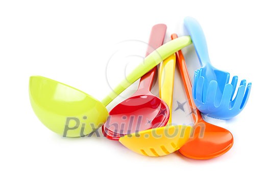 Various colorful plastic kitchen utensils on white background