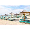 Rows of umbrellas on empty seaside beach in Greece