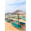 Straw umbrellas on empty seaside beach in Greece