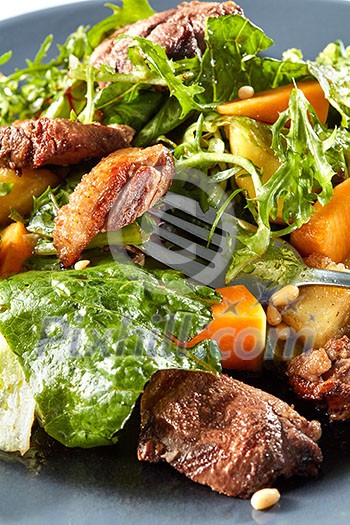 salad with pumpkin and duck meat on a fork salad with pumpkin and duck meat on a fork