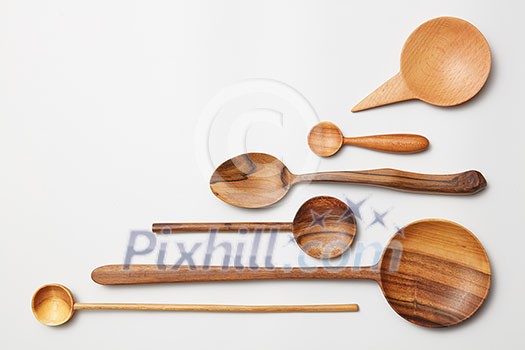 Heap of different kitchen wooden utensils cutlery on white background.