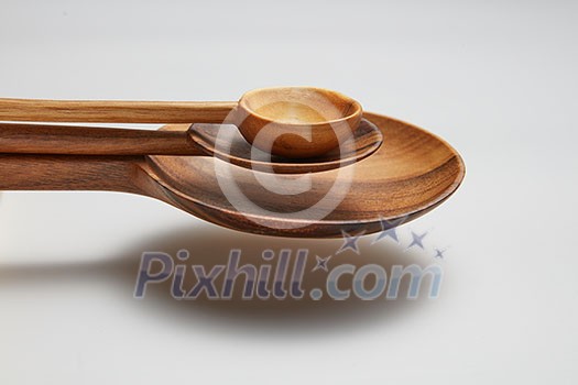 spoons different sizes of wood in air isolated on white