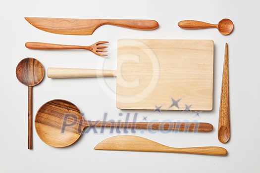 Wooden kitchen utensils on white background. Cutting board, fork, knife and spoon