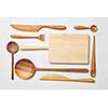 Wooden kitchen utensils on white background. Cutting board, fork, knife and spoon