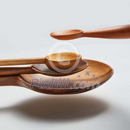 different wood spoon isolated in air on a white background