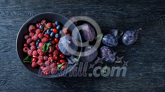 figs and berries on a dark wood background.