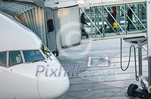 Aircraft with passage corridor/tunnel being prepared for departure from an international airport - Passangers boarding an airplane in a modern airport Aircraft with passage corridor/tunnel being prepared for departure from an international airport - Passangers boarding an airplane in a modern airport