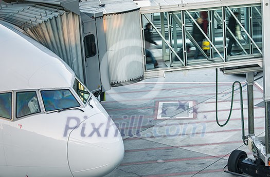 Aircraft with passage corridor/tunnel being prepared for departure from an international airport - Passangers boarding an airplane in a modern airport