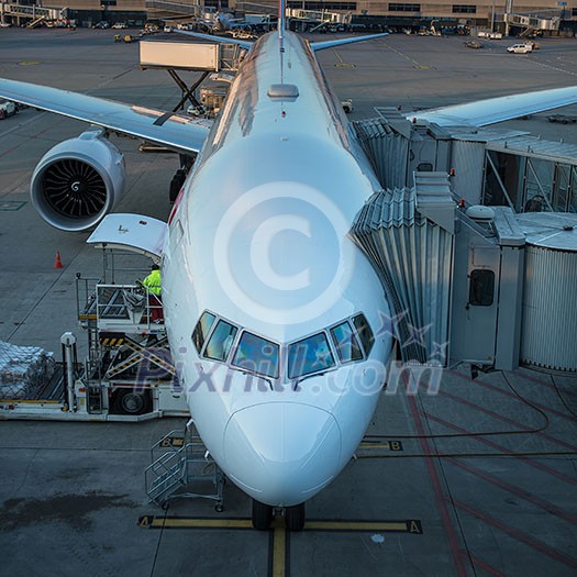 Aircraft with passage corridor/tunnel being prepared for departure from an international airport (color toned image)