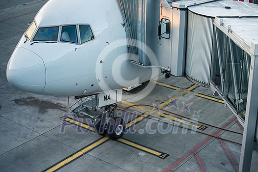 Aircraft with passage corridor/tunnel being prepared for departure from an international airport - Passangers boarding an airplane in a modern airport Aircraft with passage corridor/tunnel being prepared for departure from an international airport - Passangers boarding an airplane in a modern airport