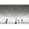 Airport rush: people with their suitcases walking along a corridor (motion blurred image; color toned image)