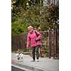 Senior woman walking her little dog on a city street; looking happy and relaxed (shallow DOF)