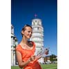 Gorgeous female tourist with map admiring the Leaning Tower of Pisa, Tuscany, Italy (shallow DOF)