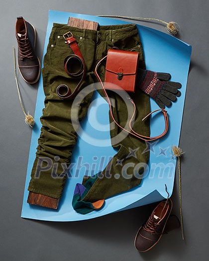 Set of mans fashion and accessories on blue paper and concrete black background