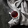 grey cozy knitted sweater with to cup of tea on a wooden black table