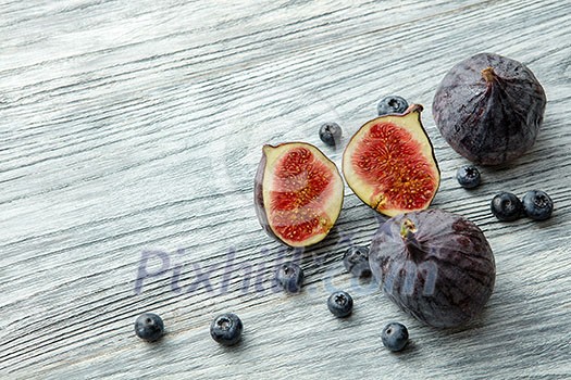 Fresh figs and blueberries, on gray background