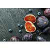 Fresh figs and blueberries, black wood background