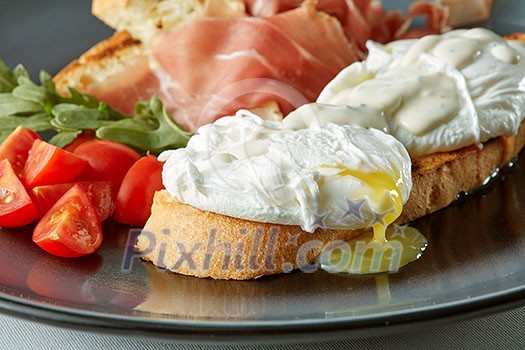 Poached egg on piece of wholegrain bread with vegetables and herbs close up