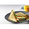 toast sandwich with salmon, vegetable and salad on plate and fresh orange juice