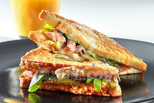 sandwich with ham and orange juice grill on the black plate sandwich with ham and orange juice grill on the black plate