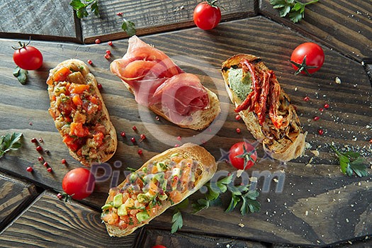 crostini with various toppings serving on wooden dark background, crostini with various toppings serving on wooden dark background,