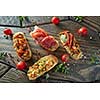crostini with various toppings serving on wooden dark background,