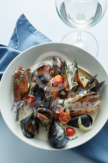 Steamed mussels in white wine sauce on the table