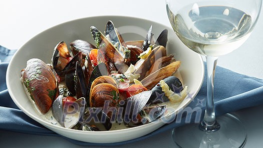 Mussels with wine, tomato and onion sauce on table
