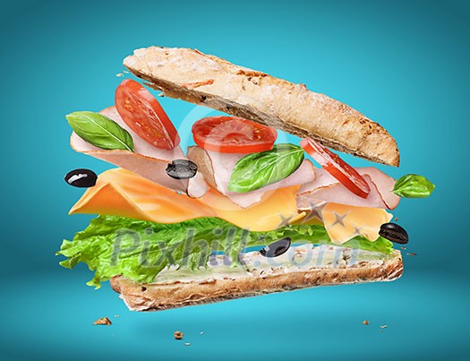 Sandwich with falling ingredients in the air isolated on blue - slices of fresh tomatoes, ham, cheese and lettuce Sandwich with falling ingredients in the air isolated on blue - slices of fresh tomatoes, ham, cheese and lettuce