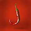Hot chilli pepper floating over red background