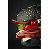 Gourmet black burger with Spicy sauce on black background