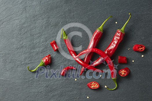 Sliced fresh red chillies isolated on a black concrete background