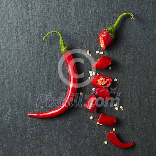 Fresh chopped red chili on a black concrete background