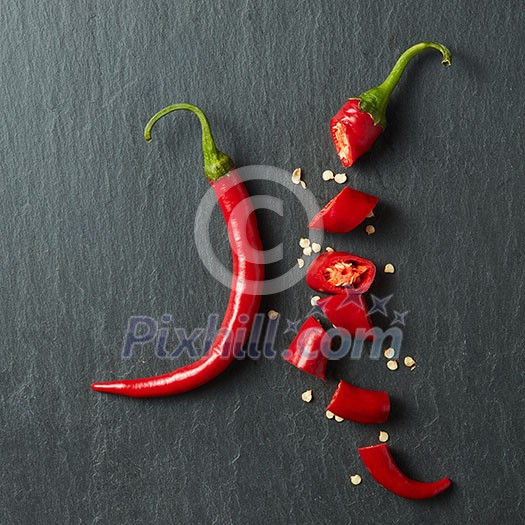 Fresh chopped red chili on a black concrete background Fresh chopped red chili on a black concrete background