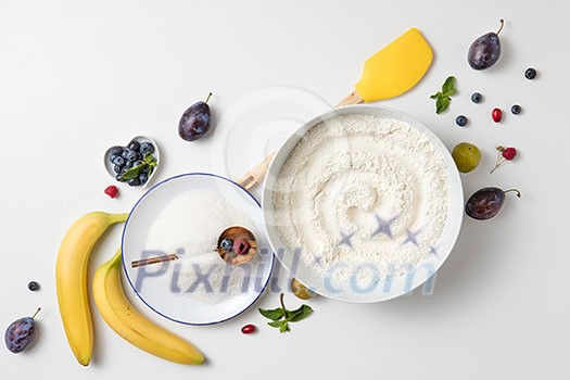 ingredients for the banana cake with berries on white background