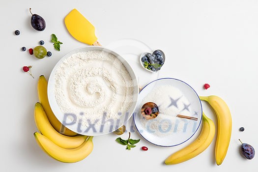 the ingredients for the banana cake with plums on white background