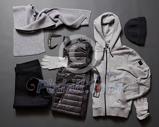 Modern men's clothing and accessories on a black background. Winter sweater, gloves, jacket, belt, knife, hat and purse