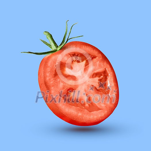 slice of red tomato with green tail isolated on a blue background