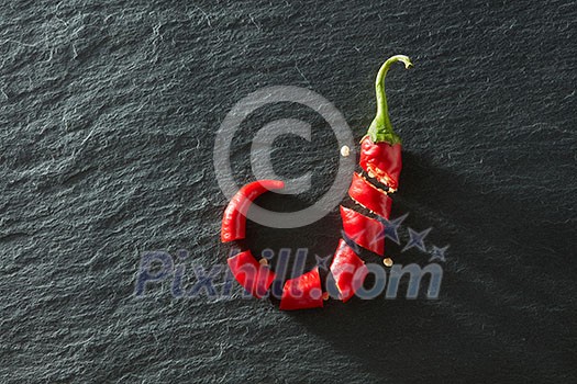 Fresh chopped red chili on a black concrete background