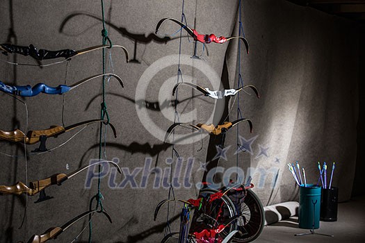 Bows and arrows in an indoor archery range - archery club Bows and arrows in an indoor archery range - archery club