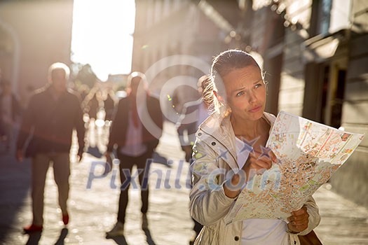 Gorgeous female tourist with a map discovering a foreign city (shallow DOF; color toned image) Gorgeous female tourist with a map discovering a foreign city (shallow DOF; color toned image)