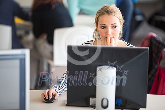 Pretty, female student looking at a desktop computer screen, learning unpleasant news about her exam results. University/office/school concept Pretty, female student looking at a desktop computer screen, learning unpleasant news about her exam results. University/office/school concept