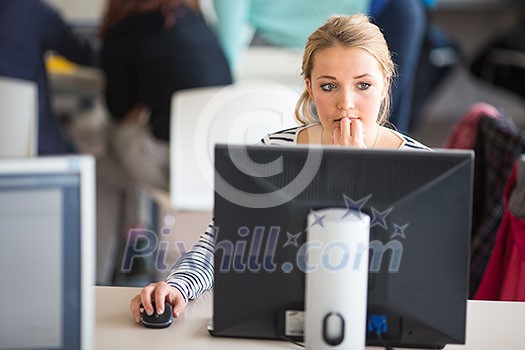 Pretty, female student looking at a desktop computer screen, learning unpleasant news about her exam results. University/office/school concept