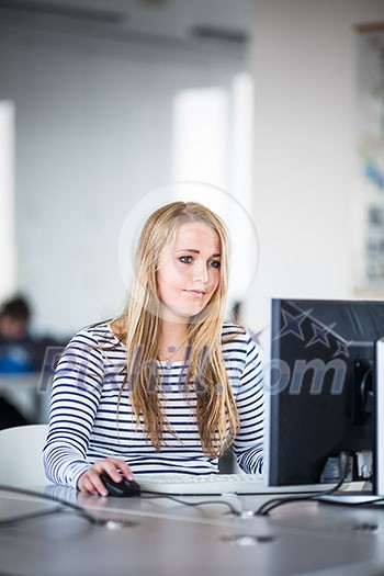 Pretty, female student looking at a desktop computer screen, learning unpleasant news about her exam results. University/office/school concept Pretty, female student looking at a desktop computer screen, learning unpleasant news about her exam results. University/office/school concept