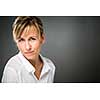 Portrait of a smiling middle aged caucasian woman against dark background - radiating confidence and feminity (shallow DOF; color toned image)