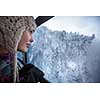 Pretty, young woman admiring splendid winter scenery from a cablecar cabin in high mountains (shallow DOF; color toned image)