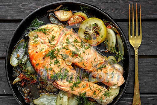 Frying pan with salmon steak, stir-fry veggies, lemon, onion and herbs, top view. Frying pan with salmon steak, stir-fry veggies, lemon, onion and herbs, top view.