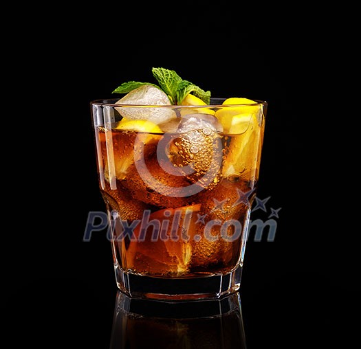 Glass of cola with ice, mint and lemon on black background.